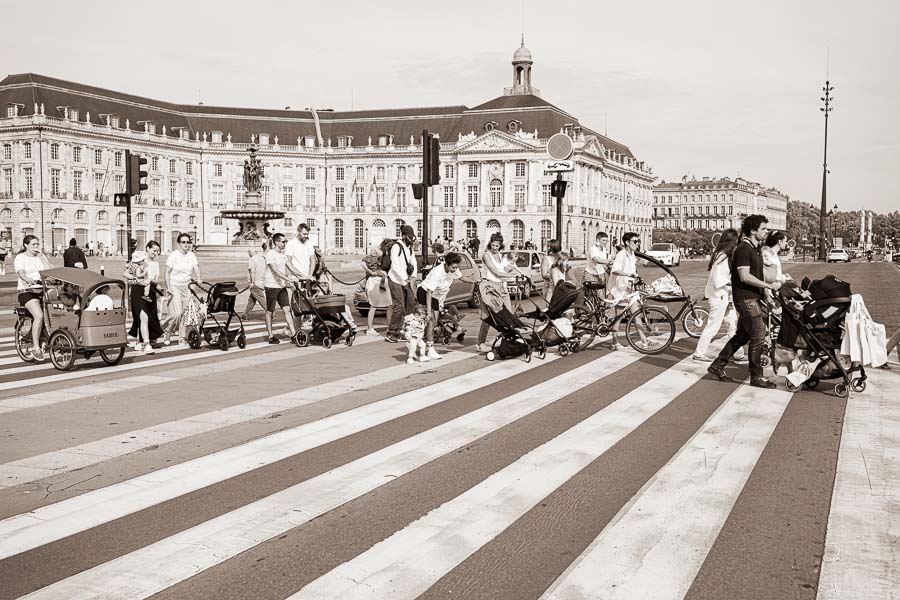 jaifaimjemange-bordeaux-2023-photographe-allaitement-marion-ziade Le cortège JAIFAIMJEMANGE traversant la route entre la place de la Bourse et le miroir d'eau.