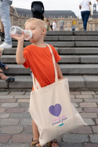 jaifaimjemange-bordeaux-2023-photographe-allaitement-marion-ziade Un enfant buvant au biberon lors de JAIFAIMJEMANGE au miroir d'eau à Bordeaux