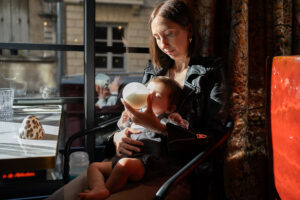 jaifaimjemange-bordeaux-2024-vitrine-ganache-marion-ziade Une maman donnant le biberon à son bébé au restaurant Ganache - JAIFAIMJEMANGE Bordeaux 2024