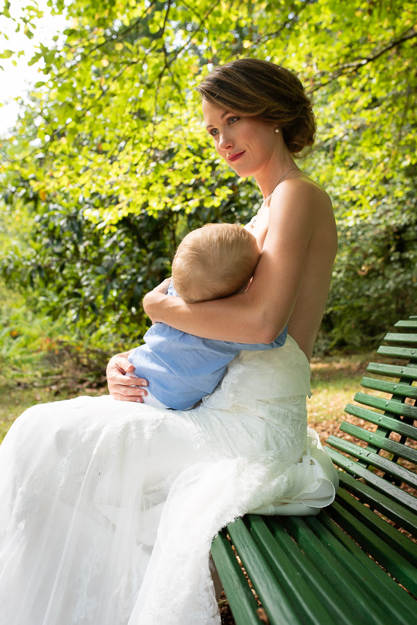 Une maman en robe de mariée allaitant son bébé